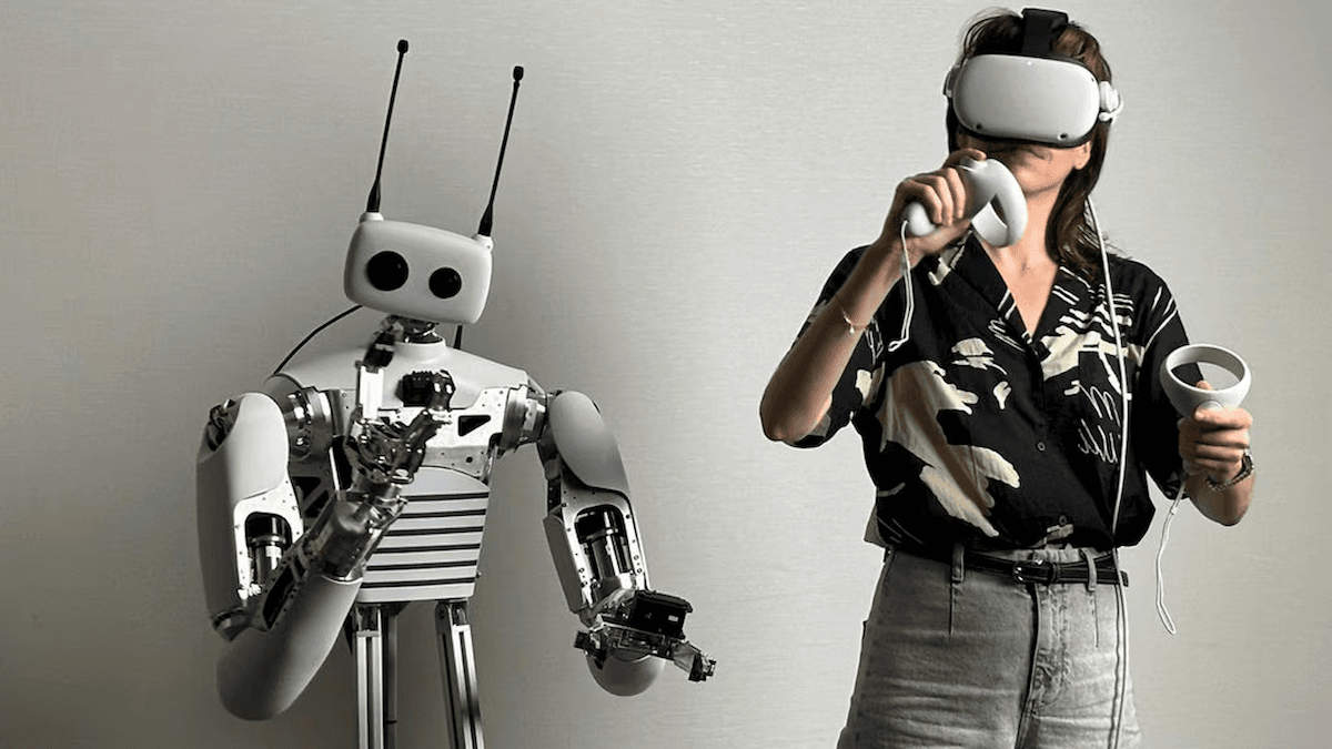 Person interacting with a humanoid robot using virtual reality headset and controllers.